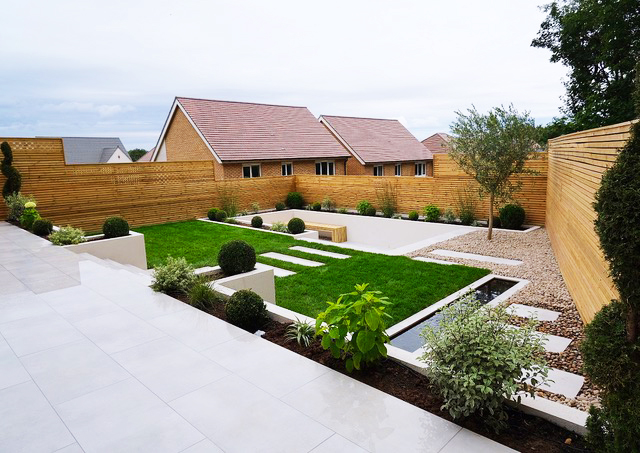 Split level garden with pale porcelain paving tiles and Scottish Pebbles