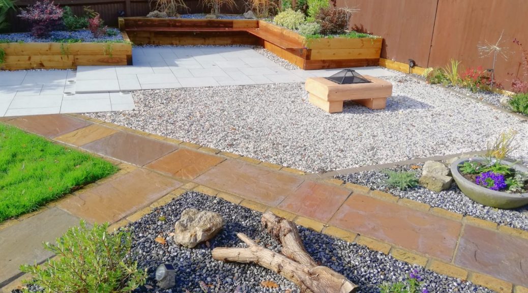 The garden with porcelain paving surrounded by Flamingo Gravel. Ocean Blue Pebbles in the raised beds.